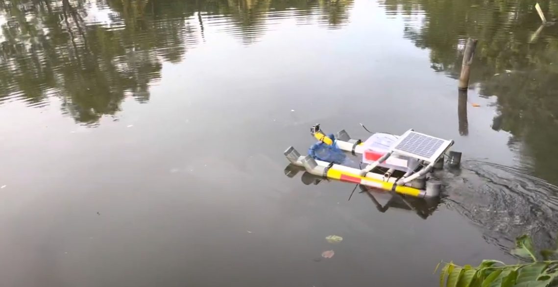 SPAT boat sailing on a lake with solar panel and collection net